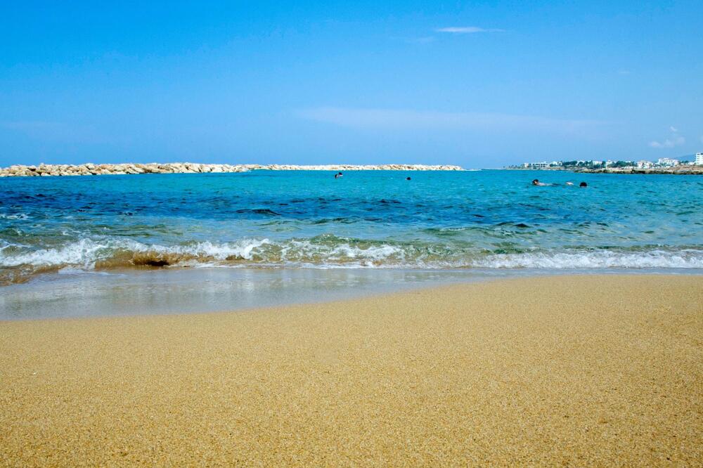 Venus Beach with calm lagoon waters protected by breakwater in Kato Paphos