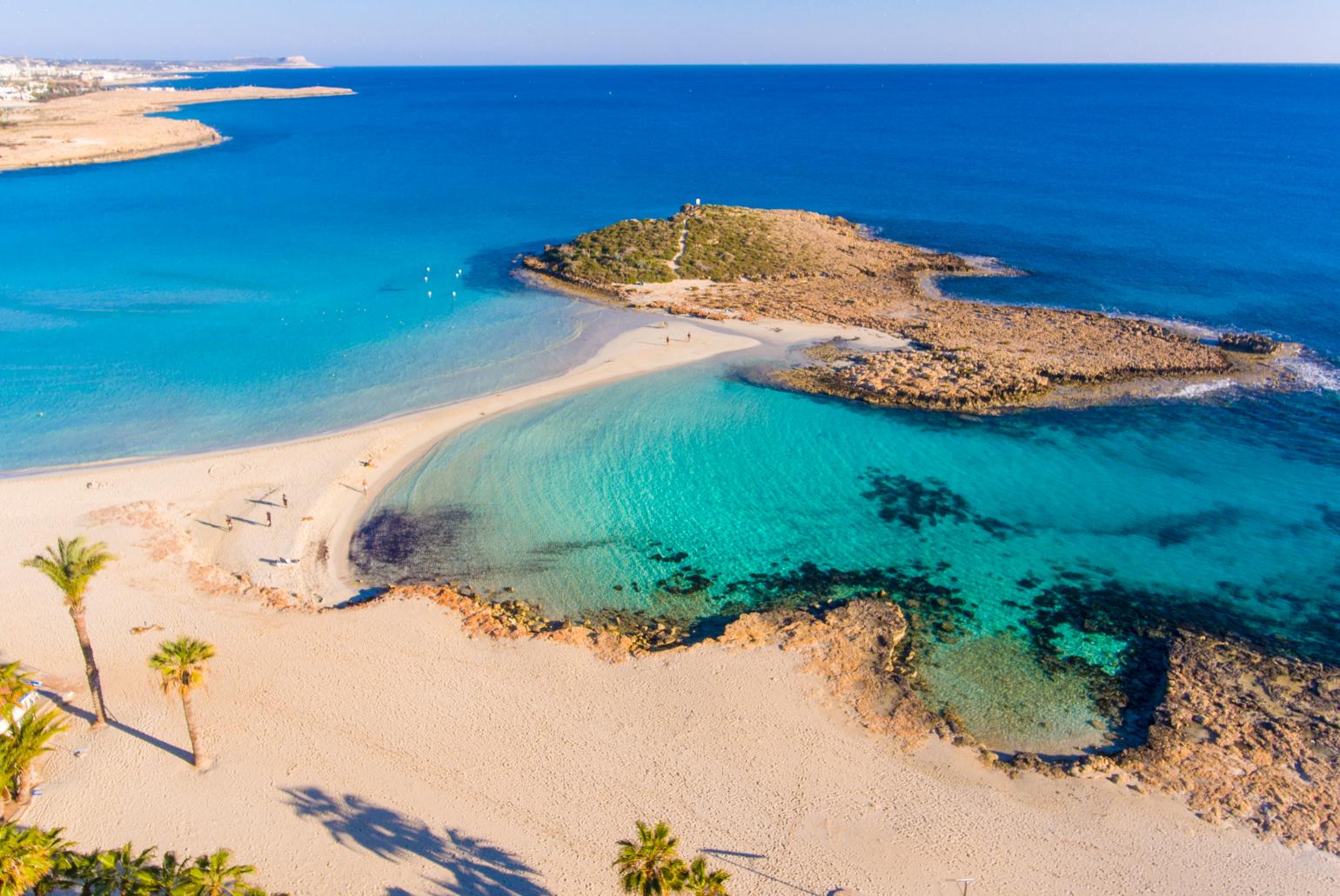 Argaka Beach with palm trees, golden sand, and crystal clear Mediterranean waters